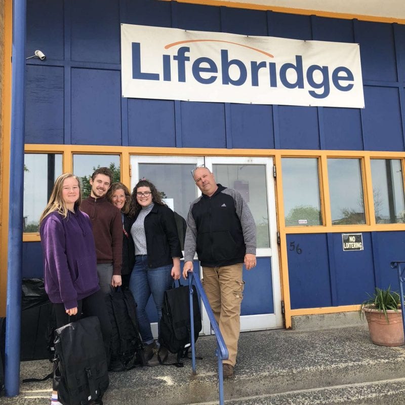 Volunteers pose for the camera at the Lifebridge Backpack Program's give a backpack day.