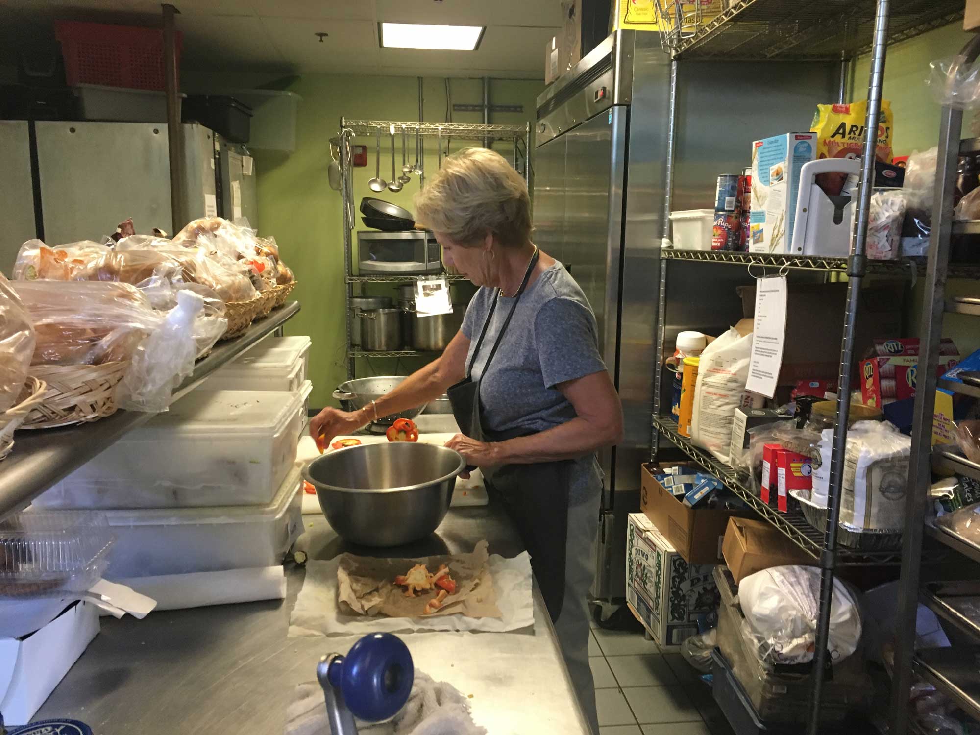 A woman in an apron prepares a community meal.