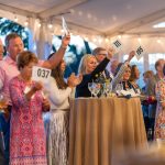 Guests raise their paddle at the Fund-a-Need for Breaking Bread, Building Hope