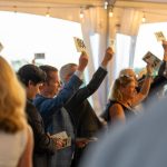Guests raise their paddles at a Fund a Need event for Breaking Bread, Building Hope