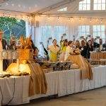 Guests raise their paddles at a Fund a Need event for Breaking Bread, Building Hope