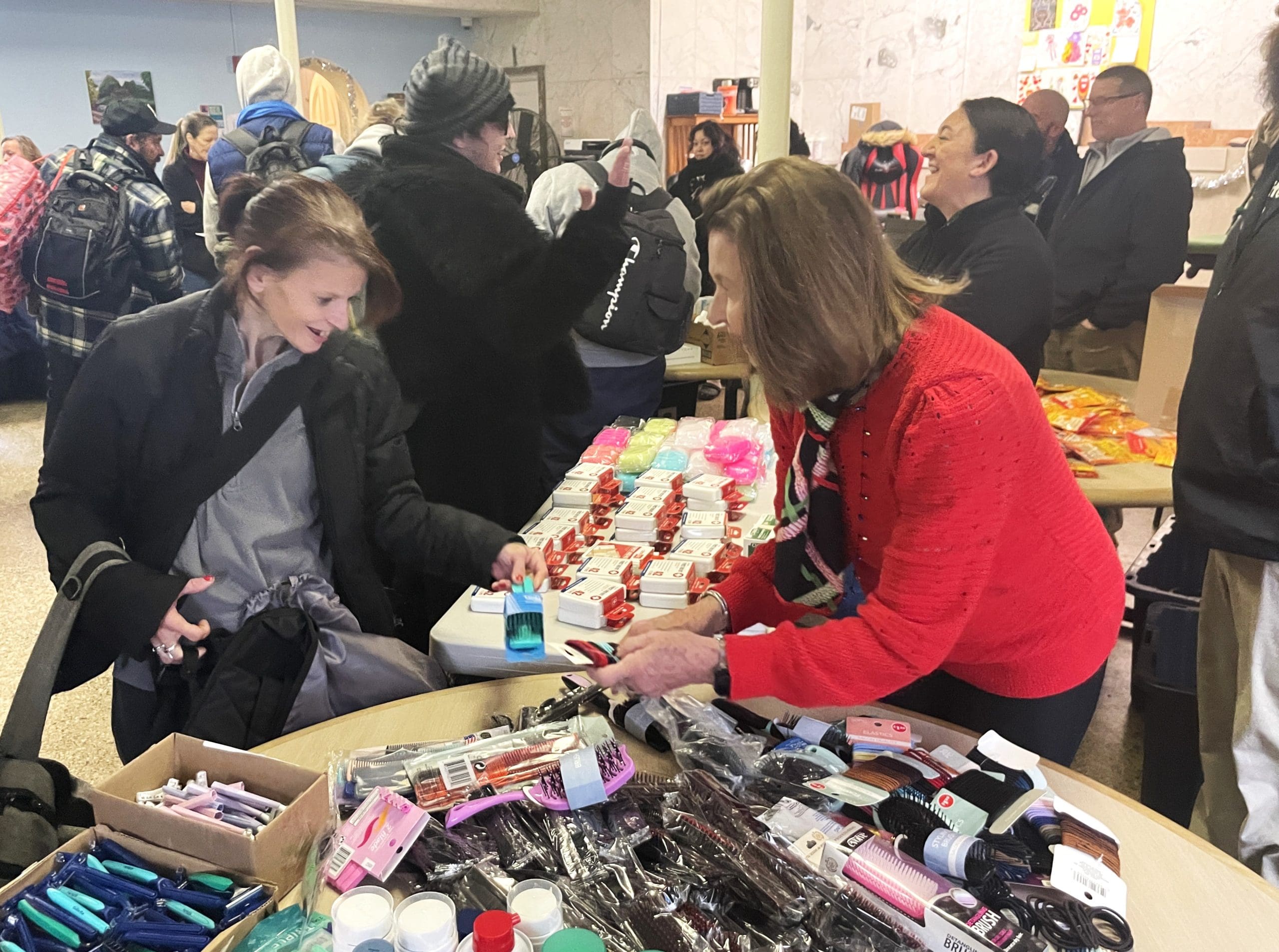 IMG_1396 A Lifebridge development committee member Lyn Freedman helps someone choose personal hygiene items at this year's Lifebridge Backpack Program Giving Day Event