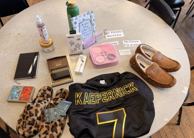 Bingo prizes including: slippers, sports jersey, airbuds, journals & pencils, body scrub & body spray, and water bottle.