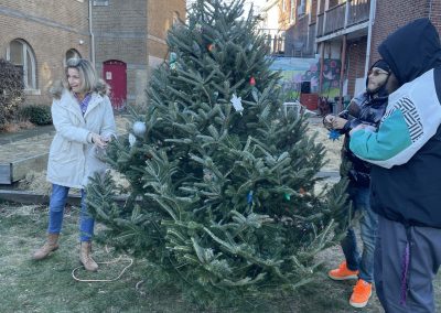 People standing around decorating the Christmas tree