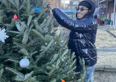 Man smiling and tying ornament to the Christmas tree