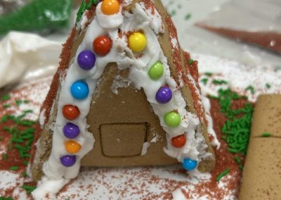 A triangle gingerbread house with colorful sprinkles