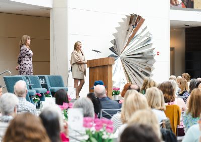 Photograph provides a wide, establishing view of the stage and venue for the formal charity fundraiser event.